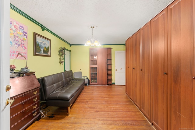 53 Columbus Ave, Bristol, CT 06010 - living area with crown molding, light wood-type flooring, a chandelier, and a textured ceiling