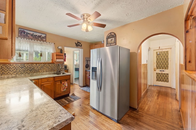 53 Columbus Ave, Bristol, CT 06010 - kitchen featuring stainless steel fridge with ice dispenser, arched walkways, a textured ceiling, light countertops, and brown cabinetry