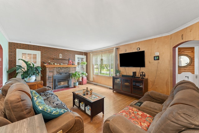 53 Columbus Ave, Bristol, CT 06010 - living room with arched walkways, ornamental molding, wood finished floors, a brick fireplace, and wood walls