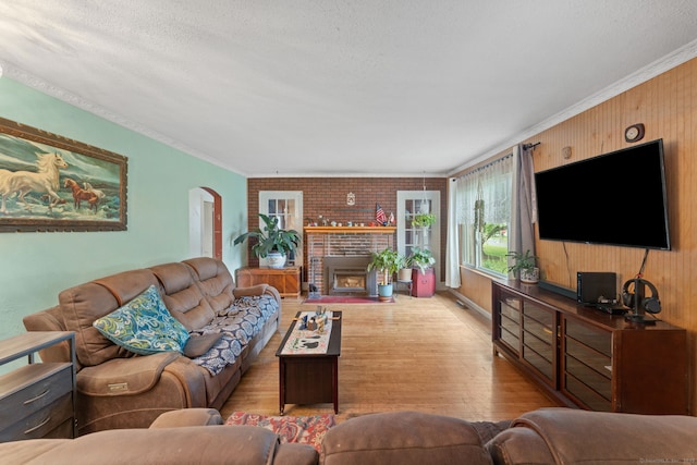 53 Columbus Ave, Bristol, CT 06010 - living room with wood finished floors, crown molding, arched walkways, a brick fireplace, and a textured ceiling