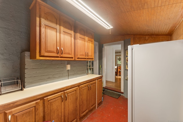 53 Columbus Ave, Bristol, CT 06010 - kitchen with freestanding refrigerator, light countertops, concrete flooring, and brown cabinets