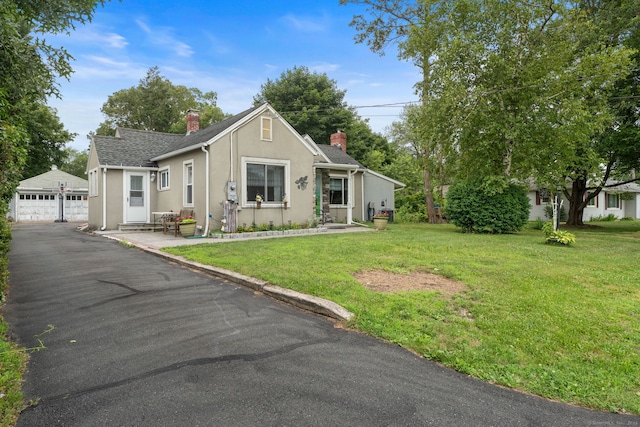 53 Columbus Ave, Bristol, CT 06010 - bungalow-style home with a chimney, an outdoor structure, a detached garage, stucco siding, and a front yard