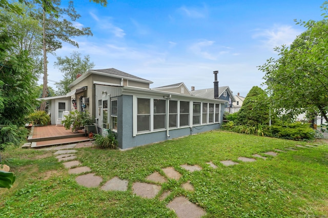 53 Columbus Ave, Bristol, CT 06010 - rear view of property featuring a sunroom, a deck, a yard, and stucco siding