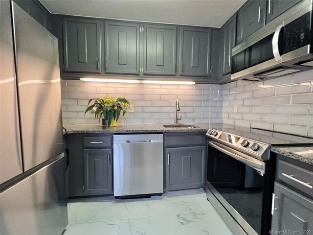296 Main Ave Unit 1, Norwalk, CT 06851 - kitchen with stainless steel appliances, light marble finish floors, stone counters, backsplash, and gray cabinetry