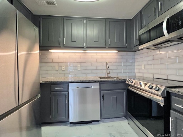 296 Main Ave Unit 1, Norwalk, CT 06851 - kitchen featuring stainless steel appliances, light stone countertops, light marble finish floors, decorative backsplash, and gray cabinets
