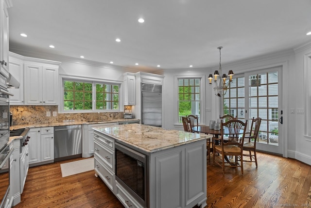 206 Fox Hopyard Rd, East Haddam, CT 06423 - kitchen with built in appliances, ornamental molding, white cabinetry, a chandelier, and dark wood-style floors
