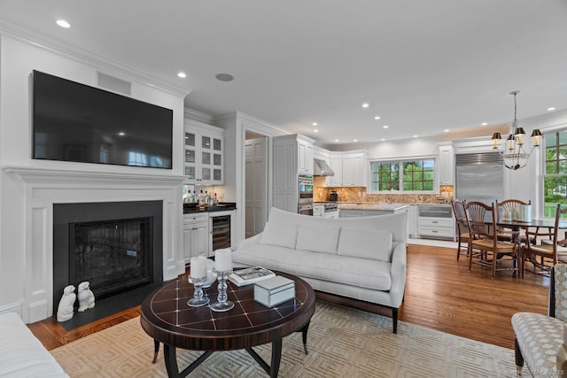 206 Fox Hopyard Rd, East Haddam, CT 06423 - living room with wine cooler, light wood finished floors, a chandelier, healthy amount of natural light, and recessed lighting