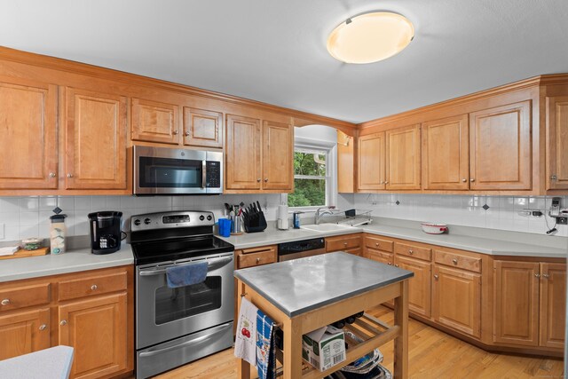 29 Jeffrey Dr, Wallingford, CT 06492 - kitchen featuring appliances with stainless steel finishes, backsplash, light wood-type flooring, and light countertops