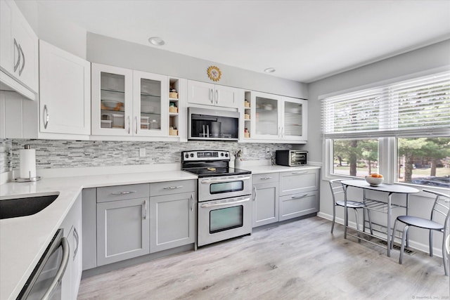 16 Juniper Cir Unit 16, Monroe, CT 06468 - kitchen with stainless steel appliances, gray cabinets, backsplash, light wood-style floors, and light countertops