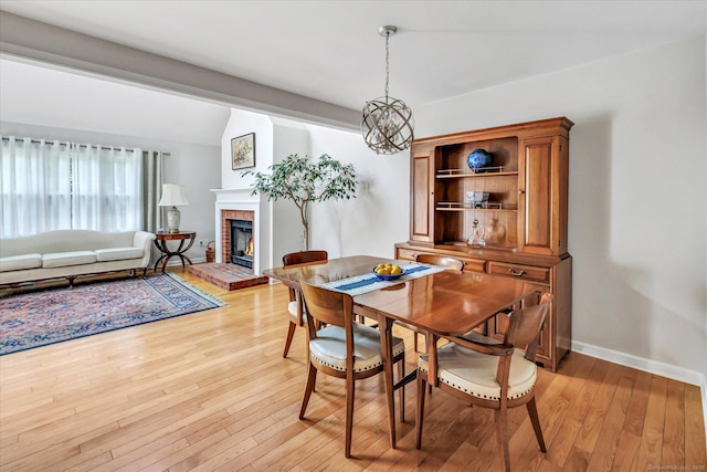 16 Juniper Cir Unit 16, Monroe, CT 06468 - dining room with light wood-type flooring, a brick fireplace, and a chandelier