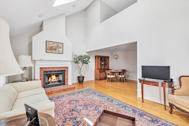 16 Juniper Cir Unit 16, Monroe, CT 06468 - living room with wood finished floors, a fireplace, a high ceiling, and a skylight