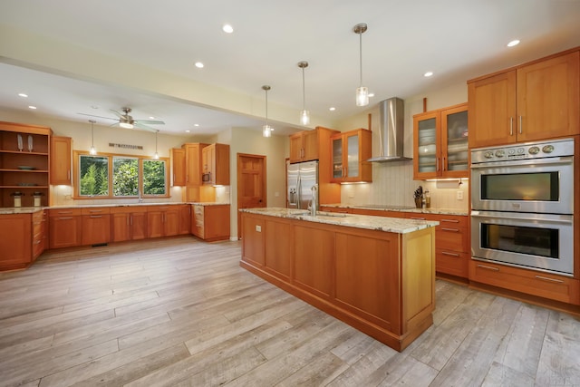 39 Beebe Rd, East Haddam, CT 06423 - kitchen featuring wall chimney range hood, appliances with stainless steel finishes, brown cabinetry, light wood-style floors, and recessed lighting