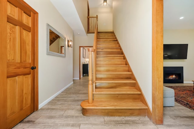 39 Beebe Rd, East Haddam, CT 06423 - staircase featuring a warm lit fireplace, wood finished floors, and recessed lighting