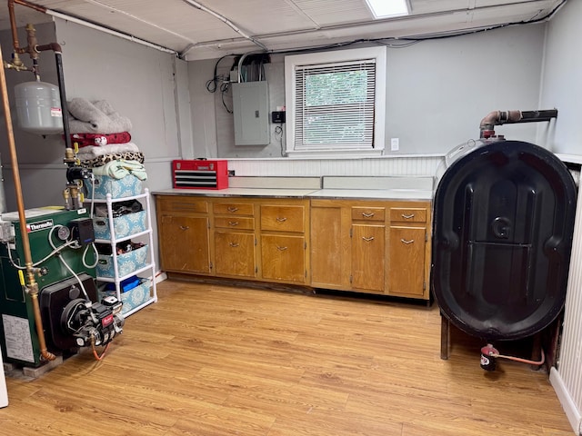 44 Coolidge St, Windsor Locks, CT 06096 - kitchen with electric panel, oil tank, light wood-style floors, light countertops, and brown cabinetry