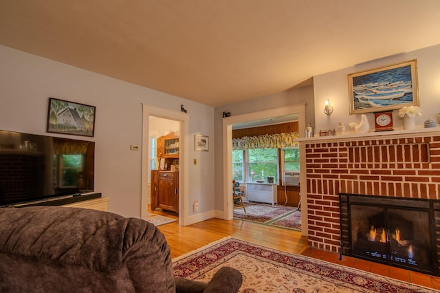 23 E St, Stafford, CT 06076 - living room featuring wood finished floors and a brick fireplace