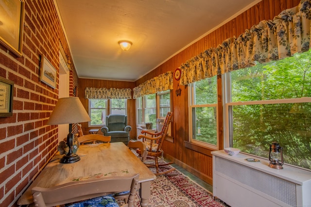 23 E St, Stafford, CT 06076 - sunroom / solarium featuring radiator heating unit, wooden walls, ornamental molding, brick wall, and wood finished floors