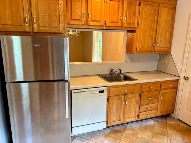 2 Apple Blossom Ln, East Lyme, CT 06357 - kitchen with freestanding refrigerator, dishwasher, light countertops, and brown cabinetry