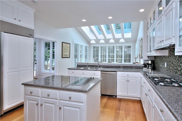 30 Soundview Farm Rd, Weston, CT 06883 - kitchen with appliances with stainless steel finishes, light wood-style floors, a skylight, a kitchen island, and vaulted ceiling