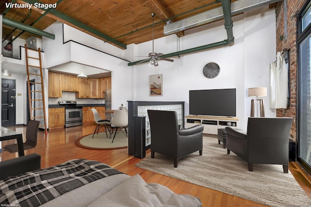 149 Water St Apt 15, Norwalk, CT 06854 - living room featuring a high ceiling, light wood finished floors, a ceiling fan, a wooden ceiling with exposed beams, and a barn door