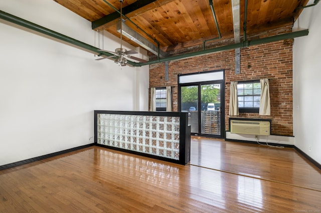 149 Water St Apt 15, Norwalk, CT 06854 - unfurnished room with a wood ceiling with exposed beams, wood finished floors, a wall unit AC, ceiling fan, and brick wall