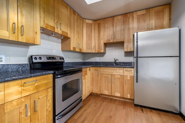 149 Water St Apt 15, Norwalk, CT 06854 - kitchen featuring stainless steel appliances, light wood-style flooring, dark stone countertops, under cabinet range hood, and tasteful backsplash