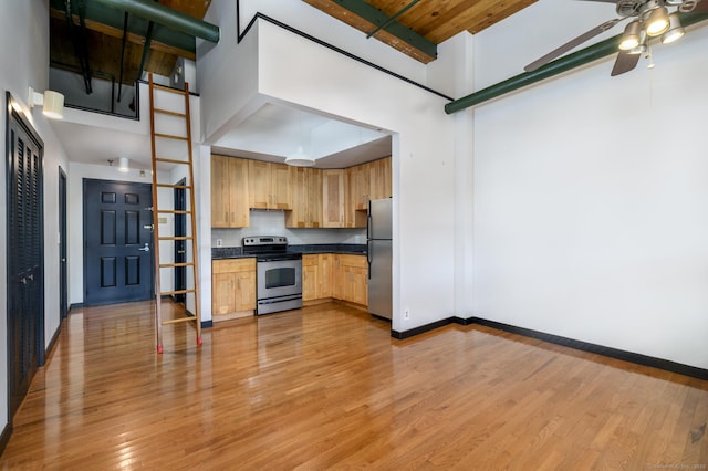 149 Water St Apt 15, Norwalk, CT 06854 - kitchen with appliances with stainless steel finishes, a high ceiling, a ceiling fan, dark countertops, and light brown cabinets