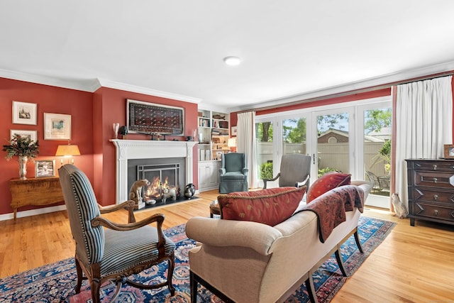312 Elm St Apt 9, New Canaan, CT 06840 - living room with crown molding, a fireplace with flush hearth, wood finished floors, french doors, and built in shelves