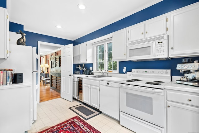 312 Elm St Apt 9, New Canaan, CT 06840 - kitchen featuring white appliances, beverage cooler, light countertops, white cabinets, and ornamental molding