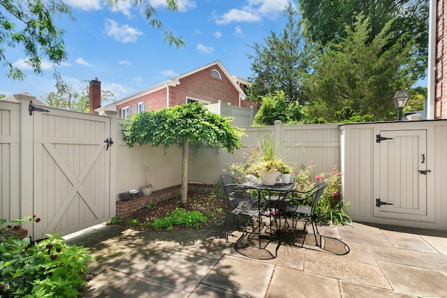 312 Elm St Apt 9, New Canaan, CT 06840 - view of patio with a gate, outdoor dining space, and a storage shed