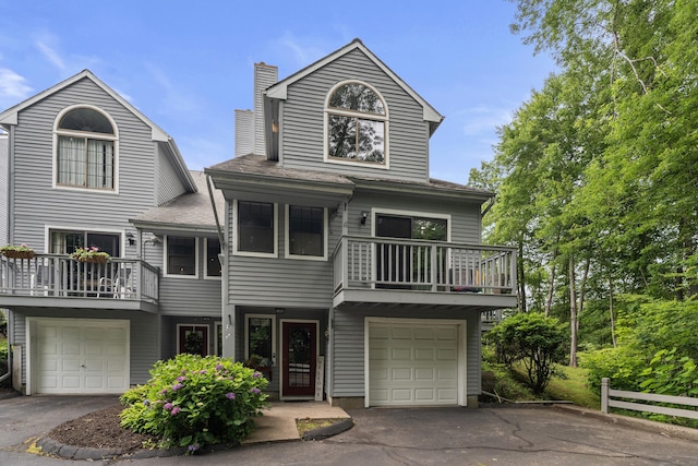 34 Village View Ter Unit 34, Meriden, CT 06451 - view of front facade featuring a balcony, a chimney, an attached garage, and driveway