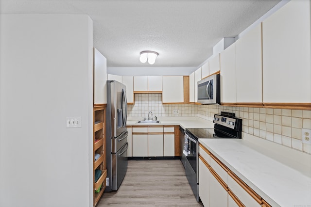 34 Village View Ter Unit 34, Meriden, CT 06451 - kitchen featuring appliances with stainless steel finishes, light countertops, white cabinets, tasteful backsplash, and a textured ceiling
