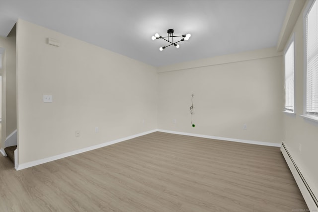 169 Mount Pleasant St, Norwich, CT 06360 - empty room featuring a baseboard heating unit, a chandelier, light wood-type flooring, and stairs