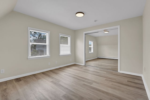 169 Mount Pleasant St, Norwich, CT 06360 - spare room with light wood finished floors, a baseboard heating unit, and vaulted ceiling