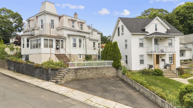 33 Aetna St, Naugatuck, CT 06770 - view of front facade featuring a balcony, stairway, and a chimney