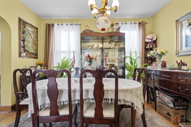 33 Aetna St, Naugatuck, CT 06770 - dining space featuring plenty of natural light, wood finished floors, a chandelier, and arched walkways