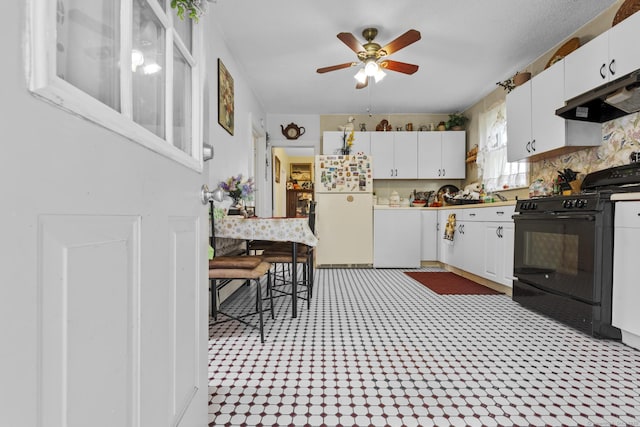 33 Aetna St, Naugatuck, CT 06770 - kitchen featuring freestanding refrigerator, black gas range oven, under cabinet range hood, and white cabinetry