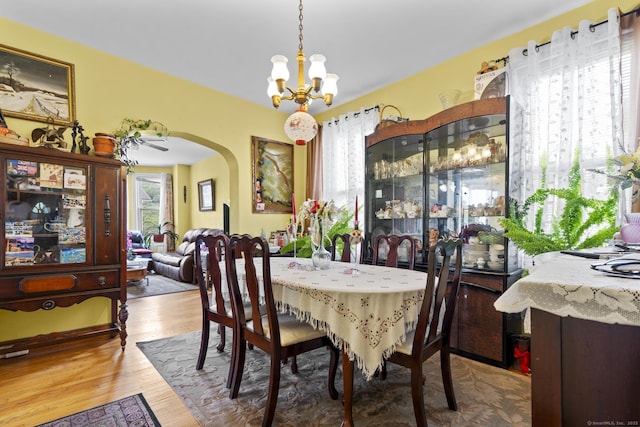 33 Aetna St, Naugatuck, CT 06770 - dining room featuring a chandelier, arched walkways, and wood finished floors