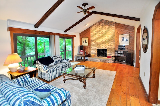 172 Bentley Cir, Goshen, CT 06756 - living room featuring a ceiling fan, light wood finished floors, wooden walls, and a brick fireplace