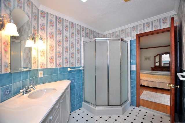 172 Bentley Cir, Goshen, CT 06756 - ensuite bathroom with a shower stall, vanity, ornamental molding, tile patterned floors, and tile walls
