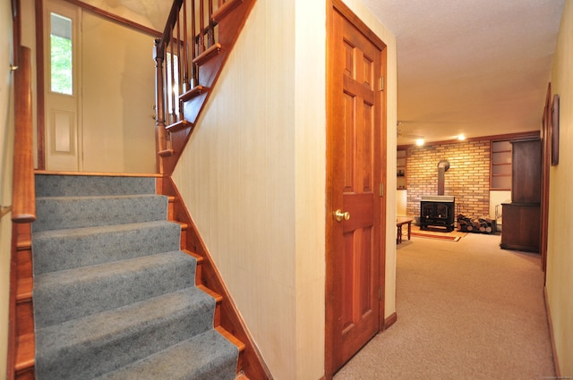 172 Bentley Cir, Goshen, CT 06756 - staircase featuring a wood stove, carpet, and brick wall