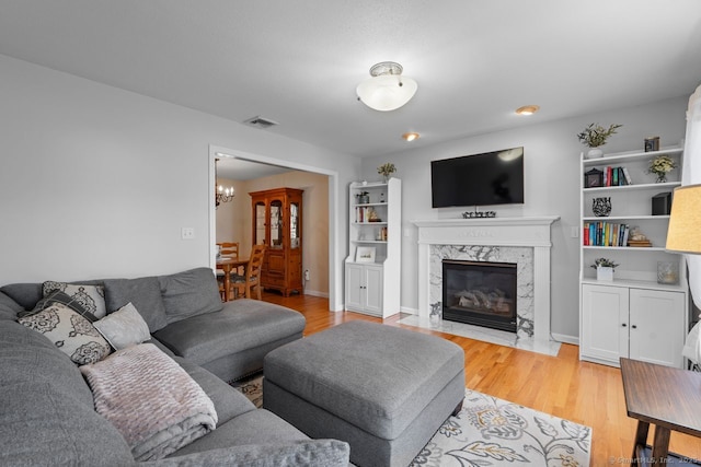 62 Peach Tree Ln, Berlin, CT 06037 - living area featuring a chandelier, a high end fireplace, and light wood finished floors