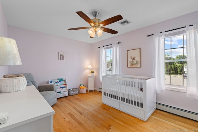 62 Peach Tree Ln, Berlin, CT 06037 - bedroom with baseboard heating, multiple windows, and light wood finished floors