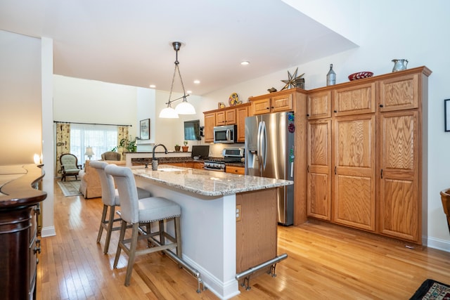 802 Dzen Way Unit 802, South Windsor, CT 06074 - kitchen featuring stainless steel appliances, light wood-style flooring, a breakfast bar area, light stone countertops, and recessed lighting