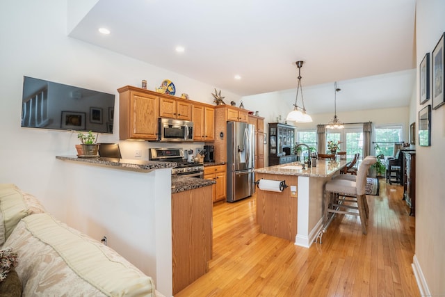802 Dzen Way Unit 802, South Windsor, CT 06074 - kitchen featuring stainless steel appliances, a breakfast bar area, light wood-style flooring, dark stone counters, and recessed lighting
