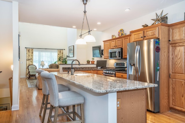 802 Dzen Way Unit 802, South Windsor, CT 06074 - kitchen featuring stainless steel appliances, a kitchen bar, light stone counters, light wood-type flooring, and recessed lighting