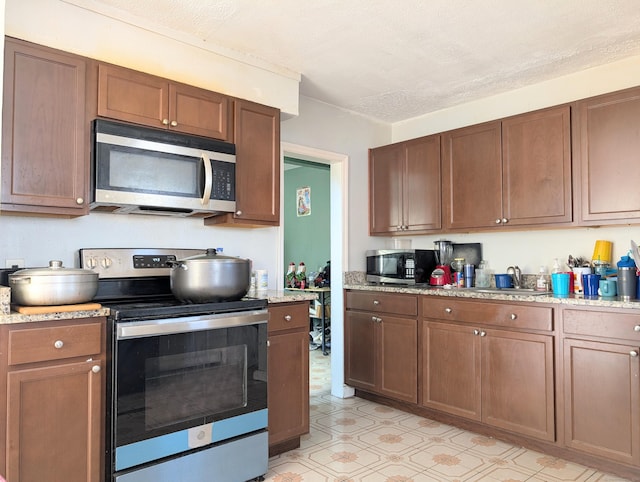 715 Burnsford Ave, Bridgeport, CT 06606 - kitchen with appliances with stainless steel finishes, light floors, and light stone counters