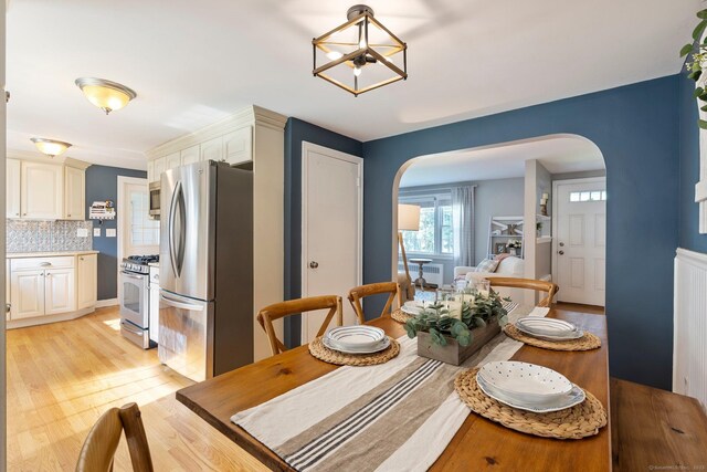 216 Main St, Glastonbury, CT 06073 - dining room featuring arched walkways, light wood-style floors, and a chandelier