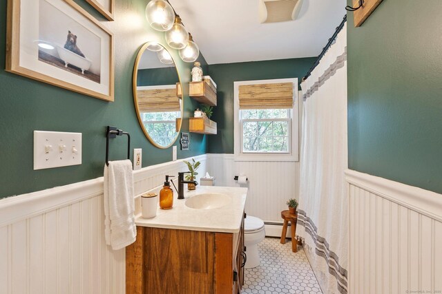 216 Main St, Glastonbury, CT 06073 - full bathroom featuring a wainscoted wall, vanity, a decorative wall, a shower with curtain, and tile patterned flooring