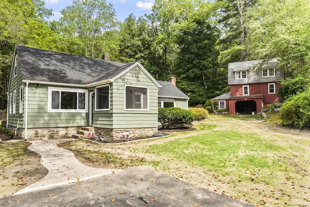 205 Great Quarter Rd, Newtown, CT 06482 - view of front of property featuring roof with shingles, an outdoor structure, a chimney, a front yard, and view of wooded area