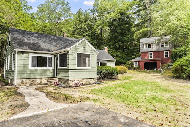 205 Great Quarter Rd, Newtown, CT 06482 - view of front of property featuring roof with shingles, an outdoor structure, a chimney, a front yard, and view of wooded area